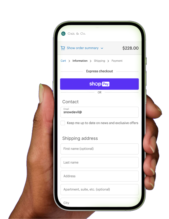 Hand holding a phone showing the Shopify checkout